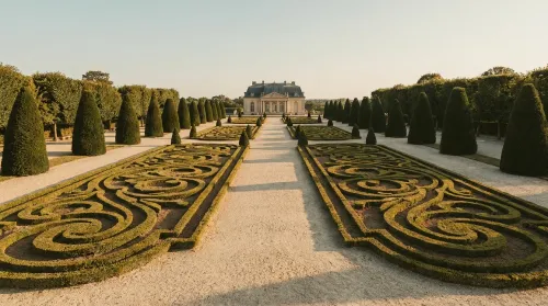 Symmetrical clipped box parterres on a central gravel axis at golden hour, one of the world's grand garden styles
